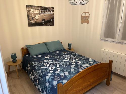 - une chambre avec un lit doté d'une couette bleue et d'un van dans l'établissement Charmante maison, à Jard-sur-Mer