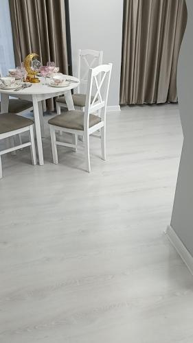 a dining room with a white table and chairs at Апартаменты Энглер in Aktobe