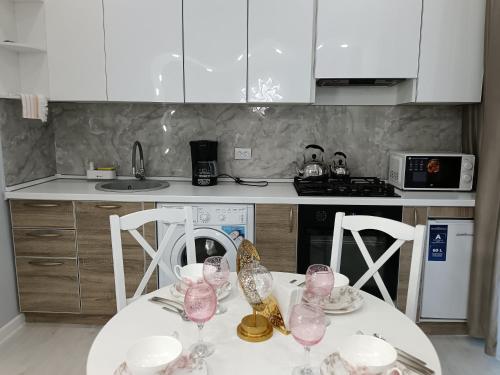 a kitchen with a table with wine glasses on it at Апартаменты Энглер in Aktobe