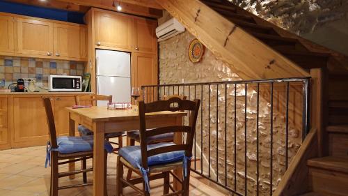 - une cuisine avec une table et des chaises en bois dans l'établissement Avalon, à Caunes-Minervois