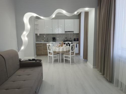 a living room and kitchen with a table and chairs at Апартаменты Энглер in Aktobe