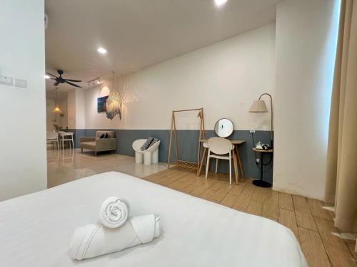 a bedroom with a white bed and a living room at ITCC Manhattan by IGVC in Penampang