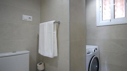 a bathroom with a washing machine and a window at Ramada Hotel & Suites by Wyndham Costa del Sol in Fuengirola