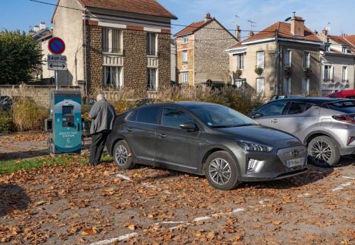 a man standing next to a car at a gas pump at Jungle Évasion, Épernay in Épernay