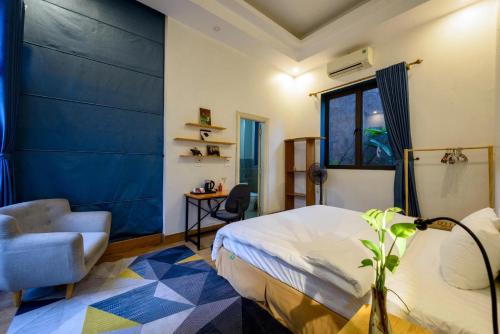 Un dormitorio con una cama y una silla y una ventana. en Orchid Villa, en Kỳ Vĩ