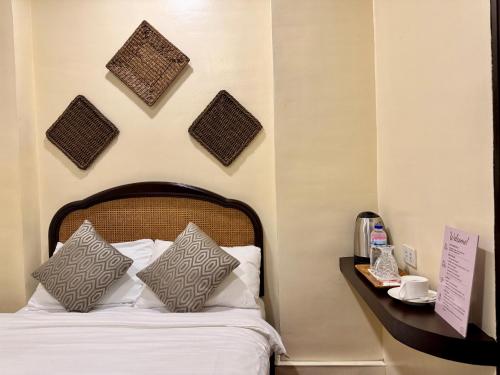a bedroom with a bed with wicker baskets on the wall at Park Avenue Boutique Hotel Manila in Manila