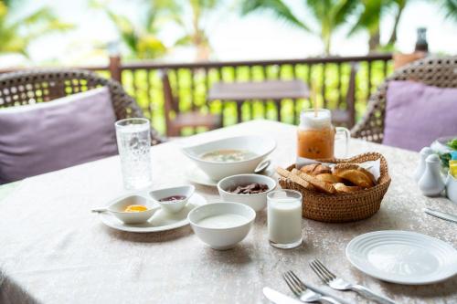uma mesa com tigelas de comida e um cesto de pão em Le Vimarn Cottages & Spa em Ko Samed