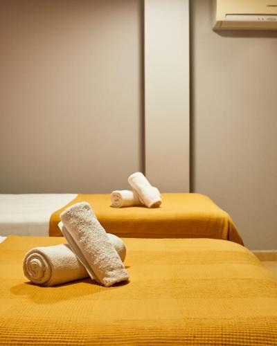 two beds with towels on them in a room at Sun & Moon Hostel in Barcelona