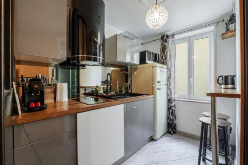 une cuisine avec un évier et un réfrigérateur dans l'établissement Coquet studio place du pin, à Nice