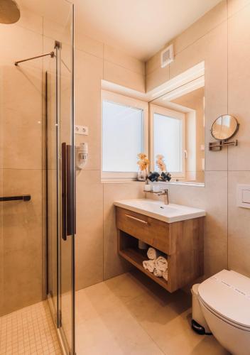 a bathroom with a toilet and a sink and a shower at Aqua Hotel Termál in Mosonmagyaróvár
