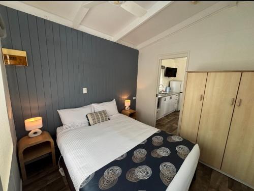 a small bedroom with a bed and a kitchen at Euroa Caravan Park in Euroa