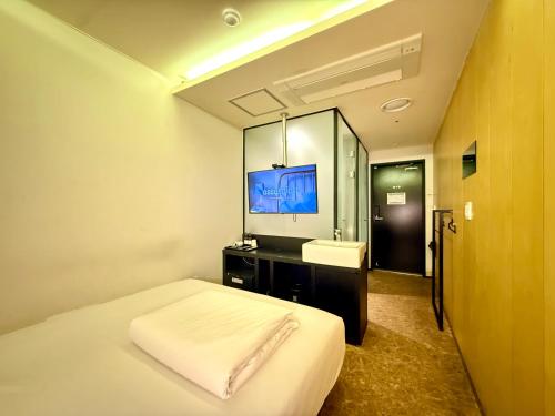 a bedroom with a bed and a sink and a mirror at Mini Hotel May Nampo in Busan