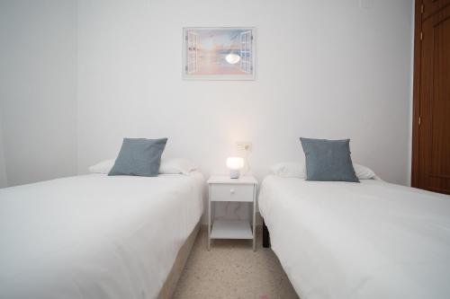 two beds sitting next to each other in a room at SIBS Sanlúcar Océano-Ideal Familias-Parking y Wifi Gratis in Sanlúcar de Barrameda
