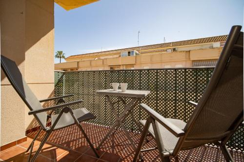 a pair of chairs and a table on a balcony at SIBS Sanlúcar Océano-Ideal Familias-Parking y Wifi Gratis in Sanlúcar de Barrameda