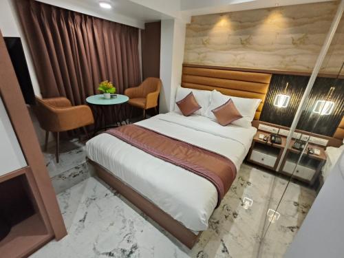 a hotel room with a bed and a table at Hotel Prime Suites Airoli in Navi Mumbai