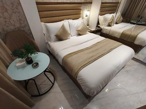 a hotel room with two beds and a table at Hotel Prime Suites Airoli in Navi Mumbai