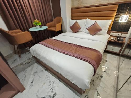a hotel room with a bed and a table at Hotel Prime Suites Airoli in Navi Mumbai