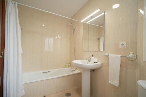 a bathroom with a sink and a tub and a shower at SIBS Sanlúcar Océano-Ideal Familias-Parking y Wifi Gratis in Sanlúcar de Barrameda