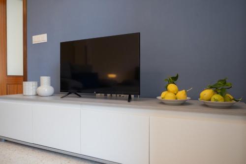 a flat screen tv sitting on top of a white cabinet at SIBS Sanlúcar Océano-Ideal Familias-Parking y Wifi Gratis in Sanlúcar de Barrameda