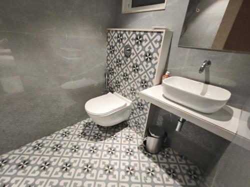 a bathroom with a white toilet and a sink at Hotel Prime Suites Airoli in Navi Mumbai