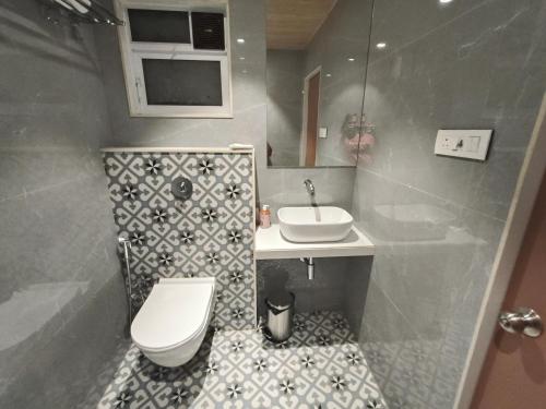 a bathroom with a toilet and a sink at Hotel Prime Suites Airoli in Navi Mumbai