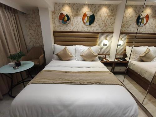 a hotel room with a bed and a table at Hotel Prime Suites Airoli in Navi Mumbai