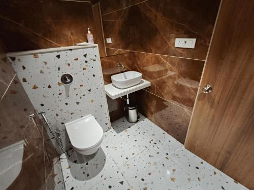 a bathroom with a toilet and a sink at Hotel Prime Suites Airoli in Navi Mumbai