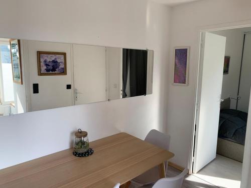 une salle à manger avec une table et un miroir dans l'établissement La Petite Hermine, gîte culturel Petits Bonheurs, à Férel