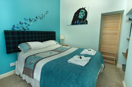 a bedroom with a bed with towels on it at Smithy Cottage in Heysham