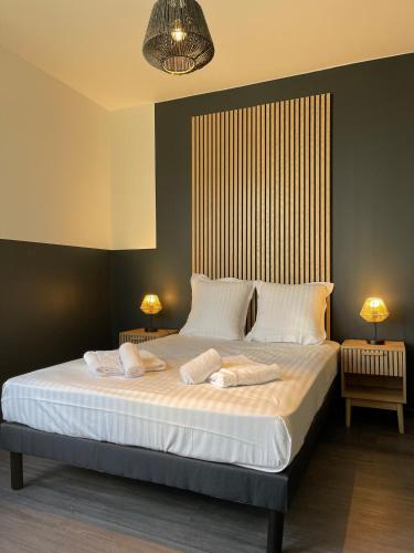 une chambre avec un grand lit avec deux oreillers dans l'établissement L'Intemporel, à Clermont-Ferrand