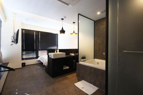 a bathroom with a tub and a sink and a bath tub at Mini Hotel May Nampo in Busan