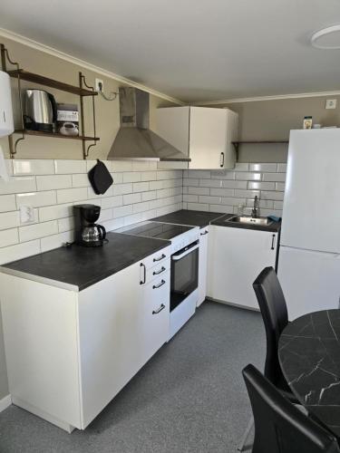 a kitchen with white appliances and a black counter top at Stora Ekeberg vandrarhem in Axvall