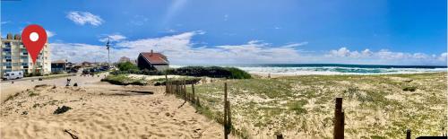 a sandy beach with a building and the ocean at La Gravière, Cozy Studio Wifi & Parking 20M Océan Surf Plage in Soorts-Hossegor