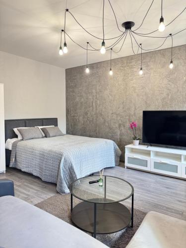 a bedroom with two beds and a tv and a table at EVIS LTD apartments 5 in Rēzekne