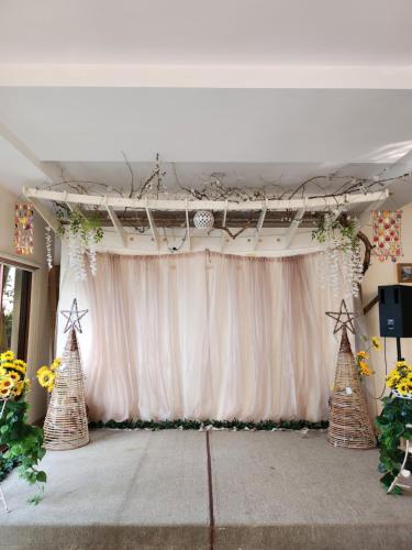 a stage with a white curtain and christmas trees at Marick Beach Resort in Carmen