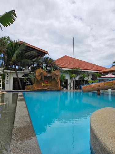 a swimming pool in front of a resort at Marick Beach Resort in Carmen