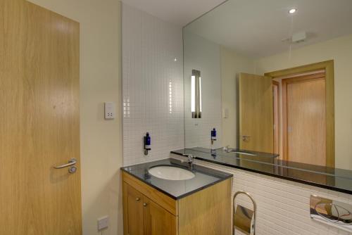 a bathroom with a sink and a mirror at No17 The Links Apartment, Brora in Brora