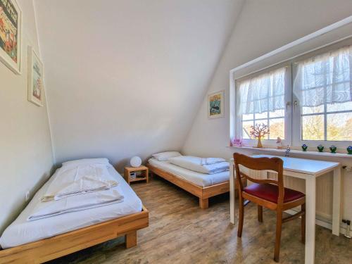 a bedroom with two beds and a desk and a chair at Sturmfrei in Greetsiel