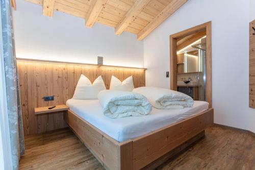 a bedroom with a large bed with a wooden headboard at Ferienwohnungen Recherhof in Hochfilzen