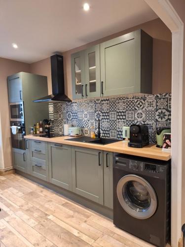 une cuisine avec une machine à laver et un lave-linge dans l'établissement La VIDA, à Saint-Pierre-du-Regard