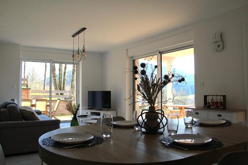 un salon avec une table et un canapé ainsi qu'une chambre avec une table dans l'établissement LE JOLI BOIS, à Colroy-la-Roche