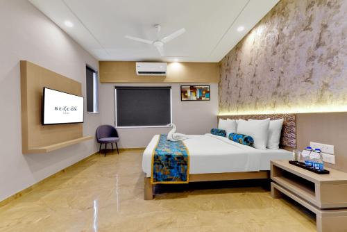 a hotel room with a bed and a tv at Iris Beacon Hotel in Rajkot