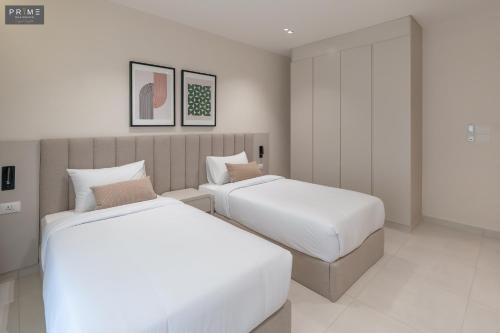 two beds in a hotel room next to each other at Prime Residence Zayed Heights in Sheikh Zayed