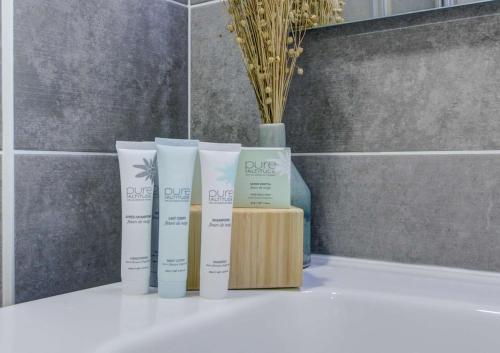 un groupe de trois produits assis sur un comptoir de salle de bains dans l'établissement Charmant penthouse au cœur de Morzine – Idéal pour le ski et le VTT, à Morzine