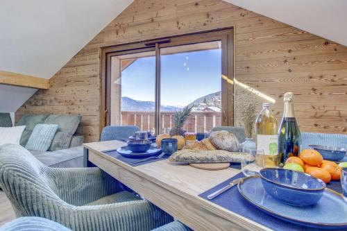 une salle à manger avec une table et des chaises et une fenêtre dans l'établissement Charmant penthouse au cœur de Morzine – Idéal pour le ski et le VTT, à Morzine