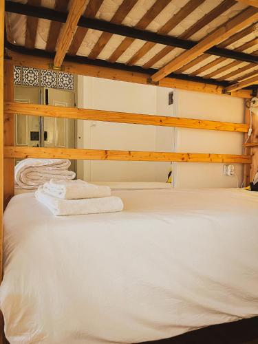 a bed with two white towels on top of it at Very Typical - Alojamento Local in Elvas