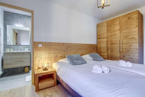 une chambre avec un grand lit blanc avec des serviettes dessus dans l'établissement Charmant penthouse au cœur de Morzine – Idéal pour le ski et le VTT, à Morzine
