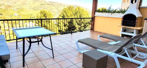 a patio with a table and chairs on a balcony at Casa Londi in Almuñécar