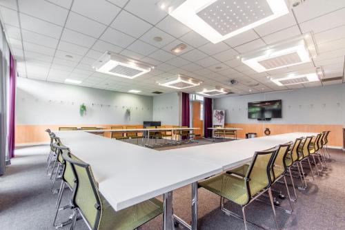 a large conference room with a large white table and chairs at Hotel Novotel Evry Courcouronnes in Evry-Courcouronnes