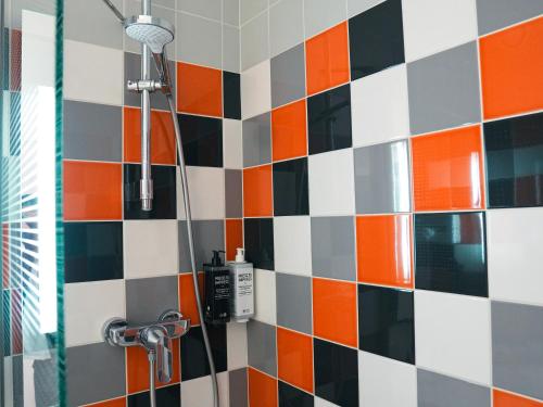 a shower in a bathroom with colorful tiles at ibis Styles Caen Centre Historique in Caen